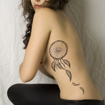  Tatouage attrape rêve avec des plumes qui tombent sur le milieu des côtes